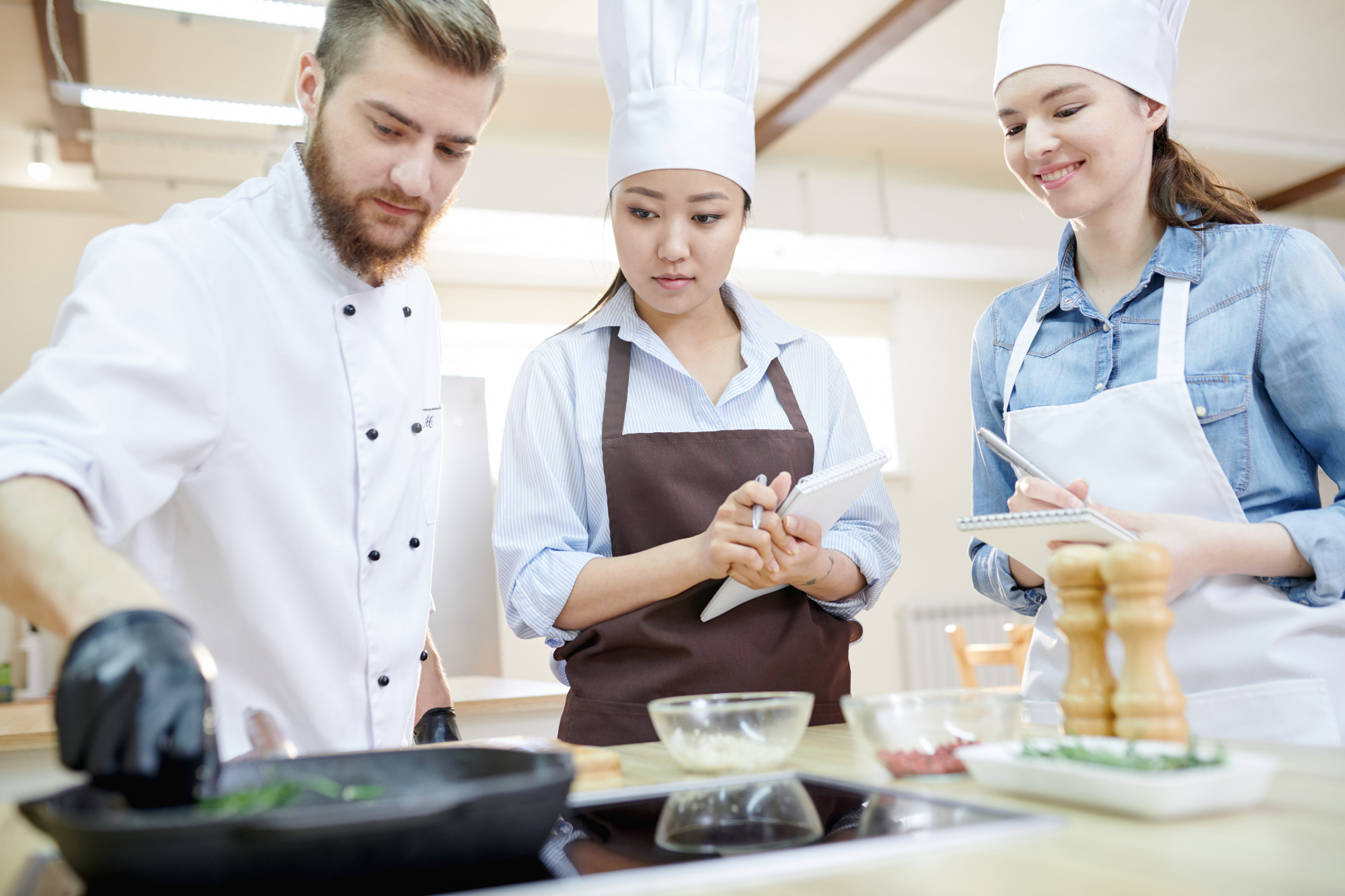 Chef teaching small class in warm kitchen